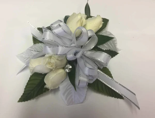 A white rose corsage with silver ribbon.