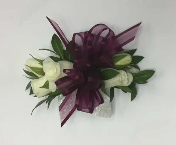 A purple bow and white flowers are on the table.