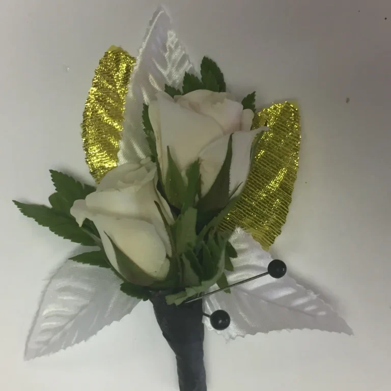 A white rose corsage with gold leaves.