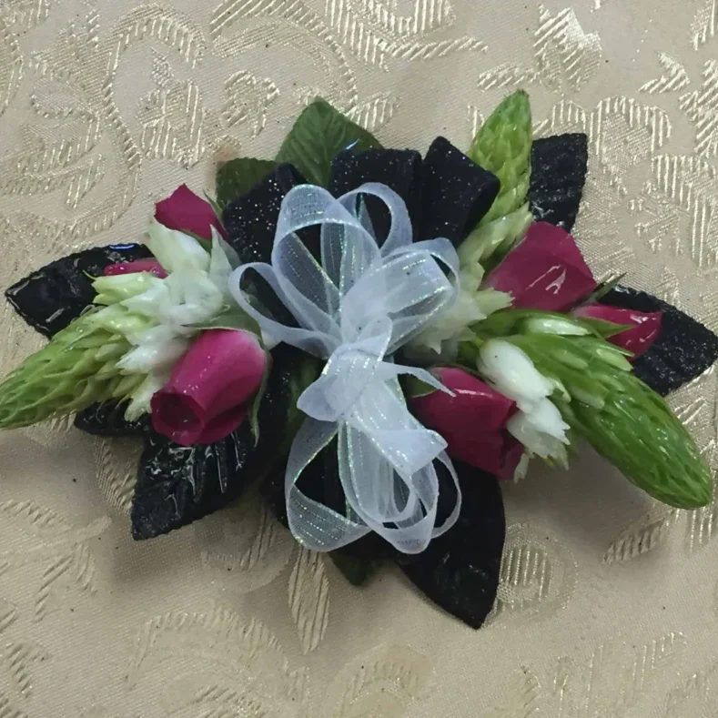 A black and white corsage with red flowers.
