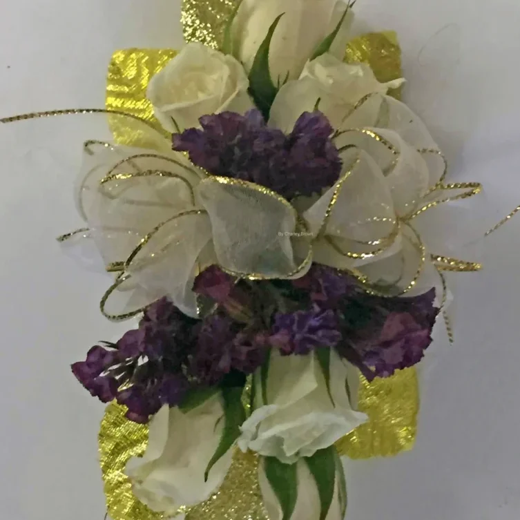 A purple and white flower arrangement on top of gold foil.