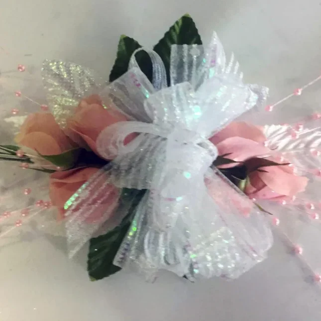 A white and pink corsage with some green leaves