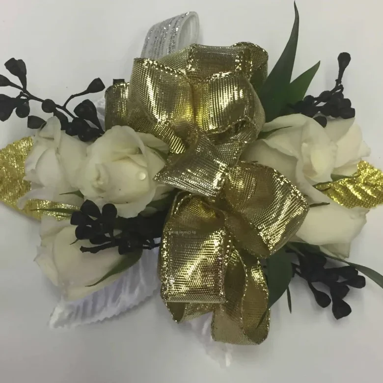 A gold bow with white flowers and black leaves.