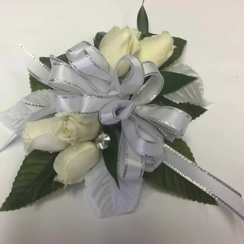 A white rose corsage with silver ribbon.