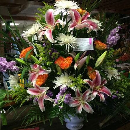 A bouquet of flowers in a vase with a tag.