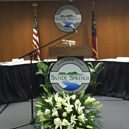 A podium with flowers and flags in the background.