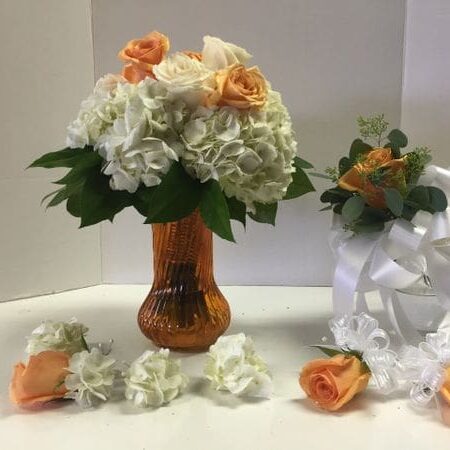 A vase of flowers and some roses on top of a table.