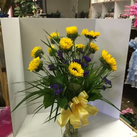 A vase filled with yellow flowers on top of a table.